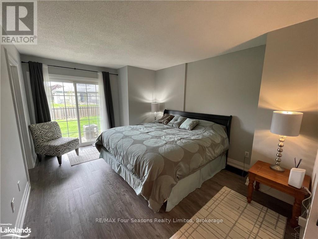 A bedroom with a large bed and a chair by the window.