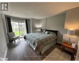 A bedroom with a large bed and a chair by the window.