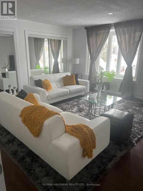 A living room with two white couches and a glass coffee table.