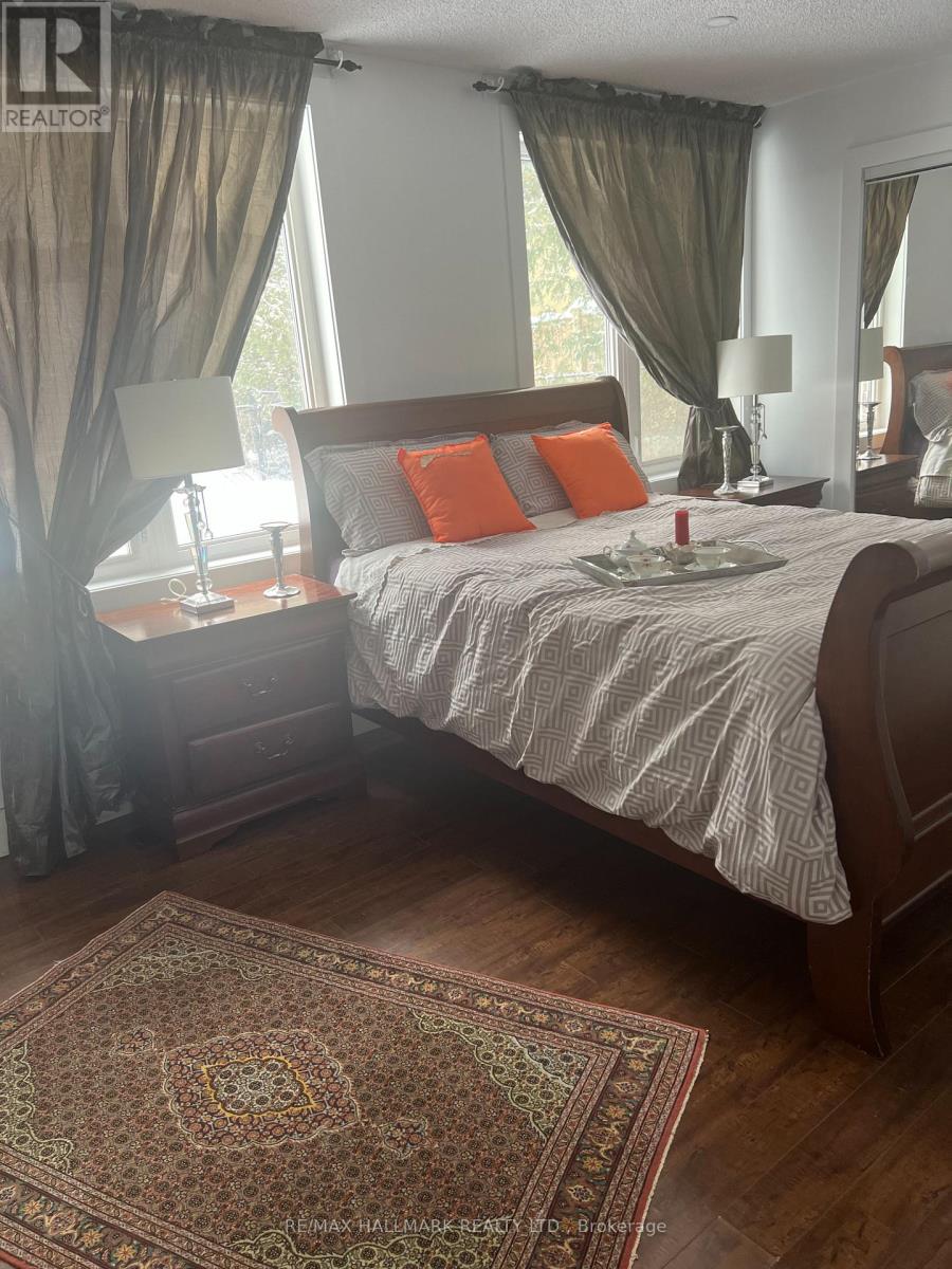 A bedroom with a large bed and a patterned rug.
