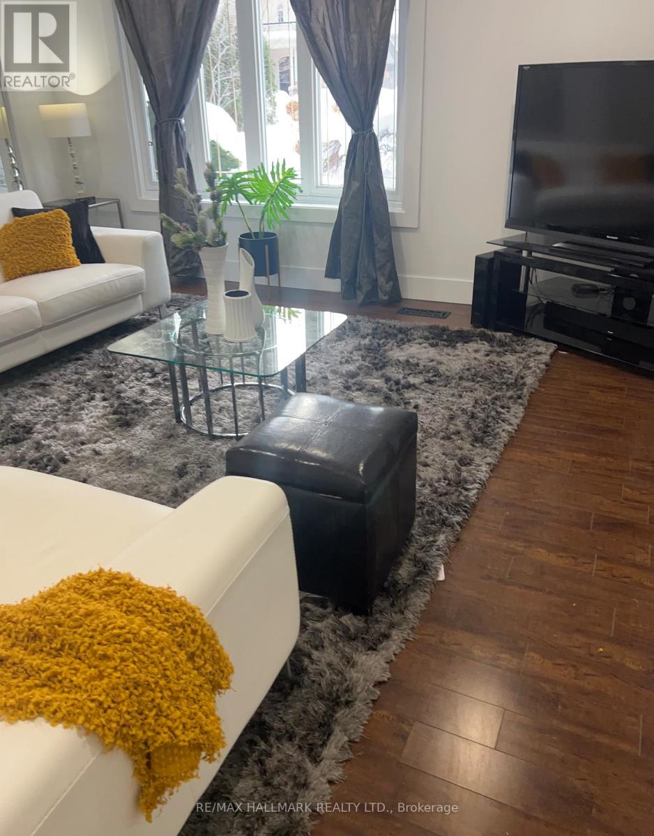A living room with two white couches and a glass coffee table.