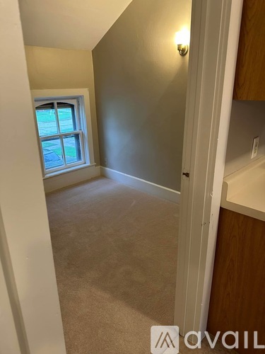A room with a window and a carpeted floor.