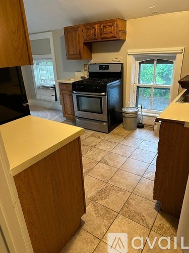A kitchen with wooden cabinets and a black stove top oven.
