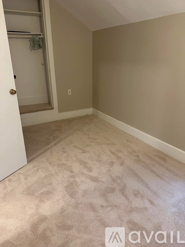 A room with beige carpet and a white door.
