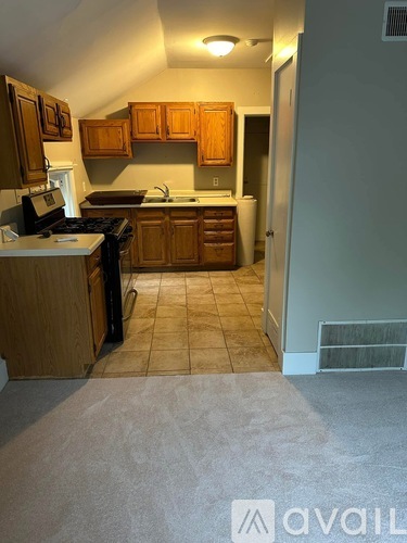 A kitchen with wooden cabinets and a white stove top oven.