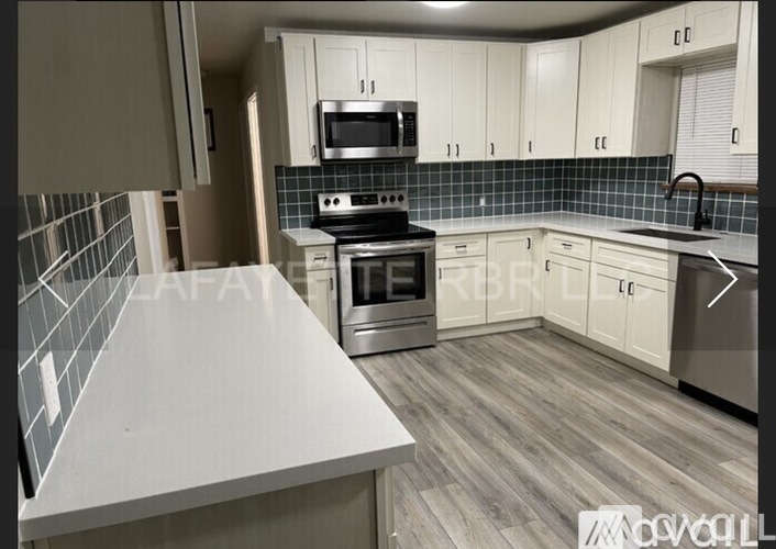 A kitchen with white cabinets and a black stove top oven.