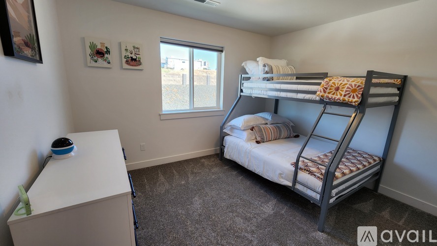 A bedroom with a bunk bed and a small white cabinet.