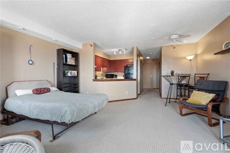 A bedroom with a bed, chair, and a television.