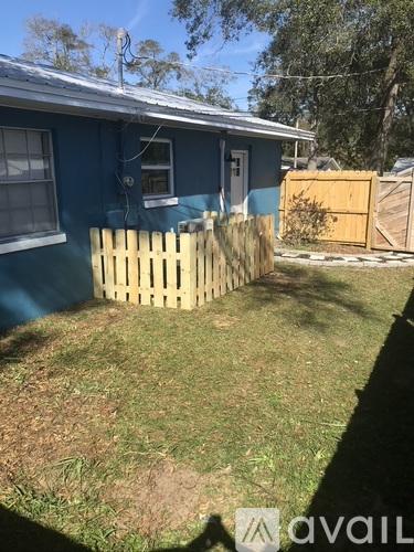 A blue house with a wooden fence in front.