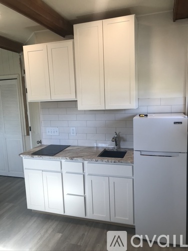 A kitchen with white cabinets and a white refrigerator.