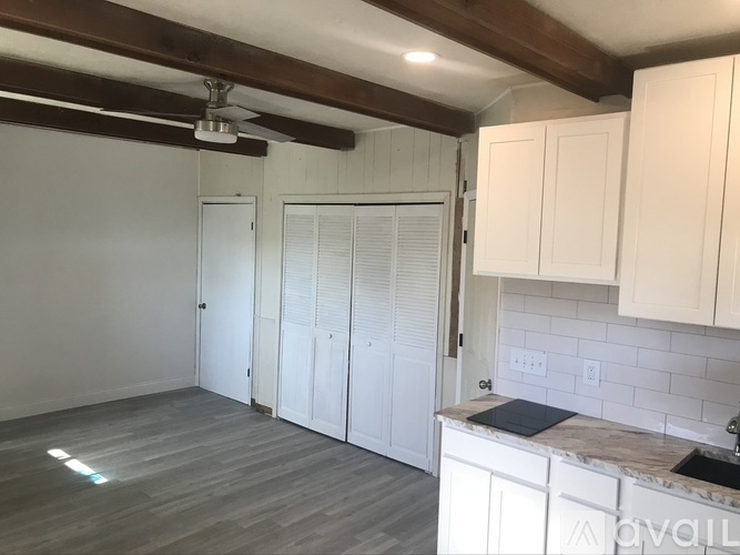 A kitchen with white cabinets and a marble countertop.