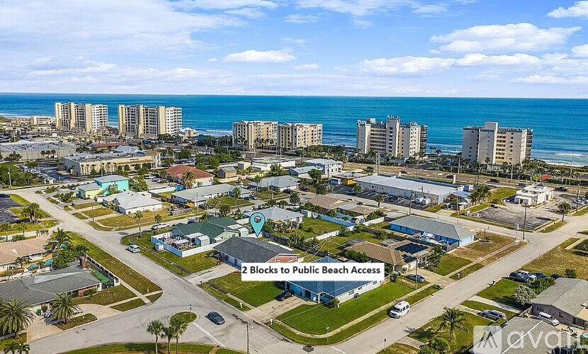An aerial view of a beachfront area with a sign indicating "2 Blocks to Public Beach Access.".