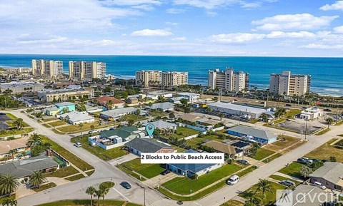 An aerial view of a beachfront area with a sign indicating "2 Blocks to Public Beach Access.".