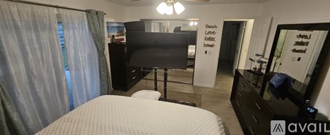 A bedroom with a large bed and a flat screen TV.