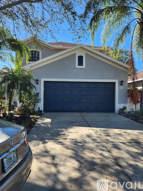 A house with a closed blue garage door and a silver car parked in front.