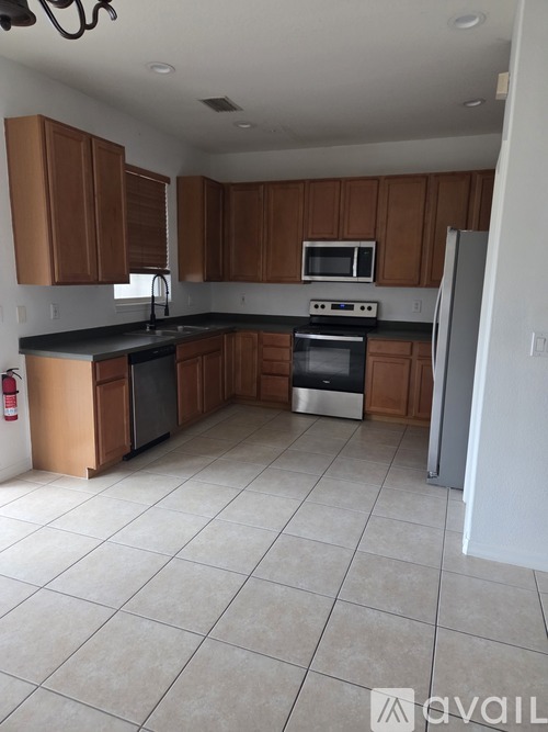 A kitchen with brown cabinets and black countertops.