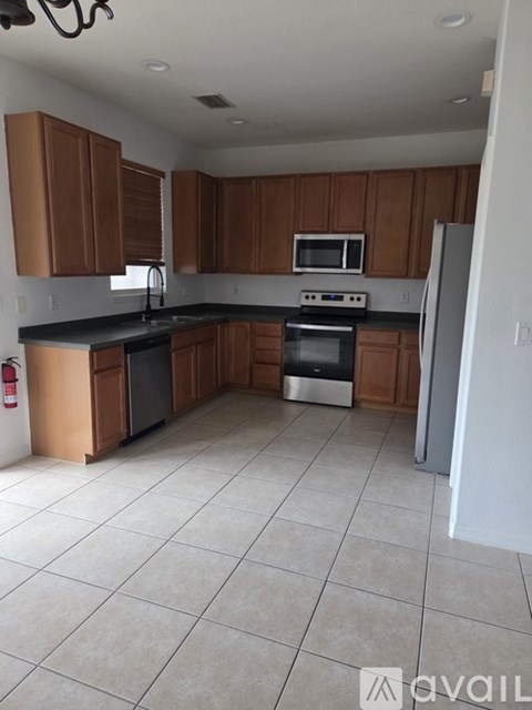 A kitchen with brown cabinets and black countertops.
