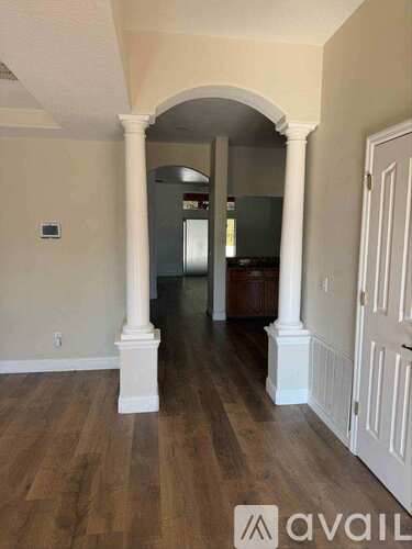 A hallway with a white door and a white column.