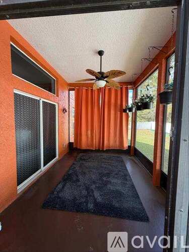 A room with orange walls and a ceiling fan.