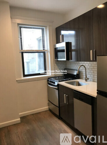 A kitchen with a sink, stove, and microwave.