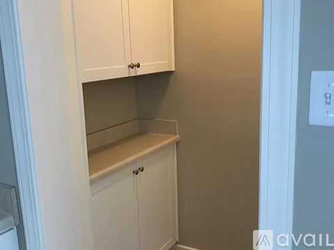 A kitchen with white cabinets and a light switch.