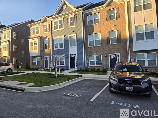 A black car is parked in a parking lot in front of a building.