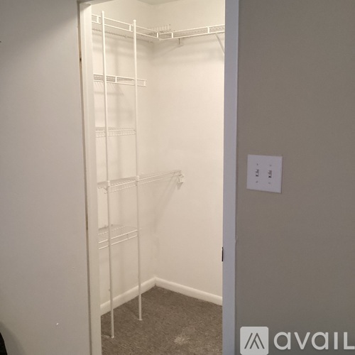 A white closet with shelves and a sign on the wall.