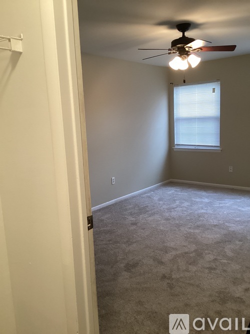 A room with a ceiling fan and a window.