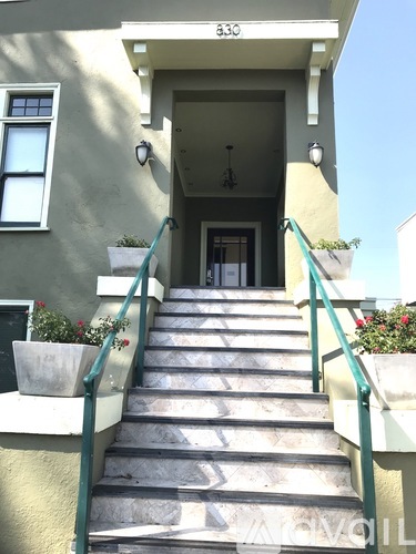 A staircase with a green railing leads to a doorway.