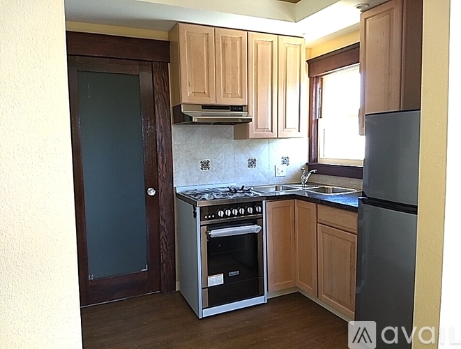 A kitchen with wooden cabinets and a stainless steel refrigerator.