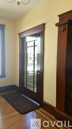 A room with a brown door and a brown mat on the floor.