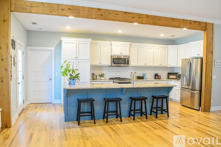 A kitchen with wooden beams and a blue island.