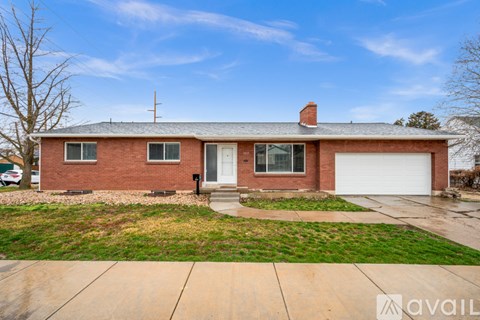 A red brick house with a white garage door and a chimney.
