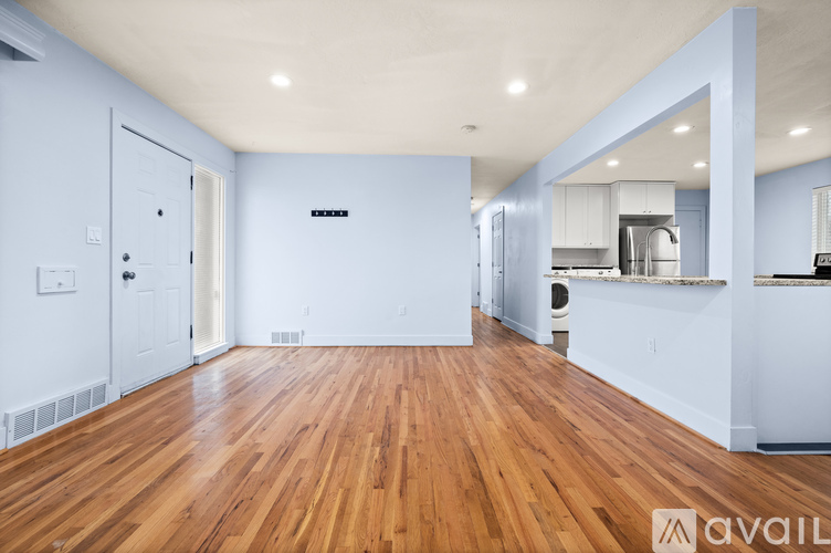 A spacious room with wooden floors and white walls.