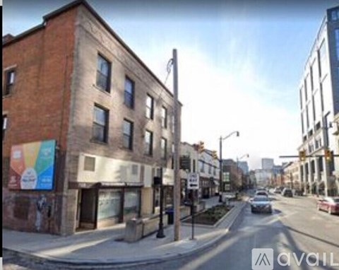 A street view of a city with a car driving down the road.