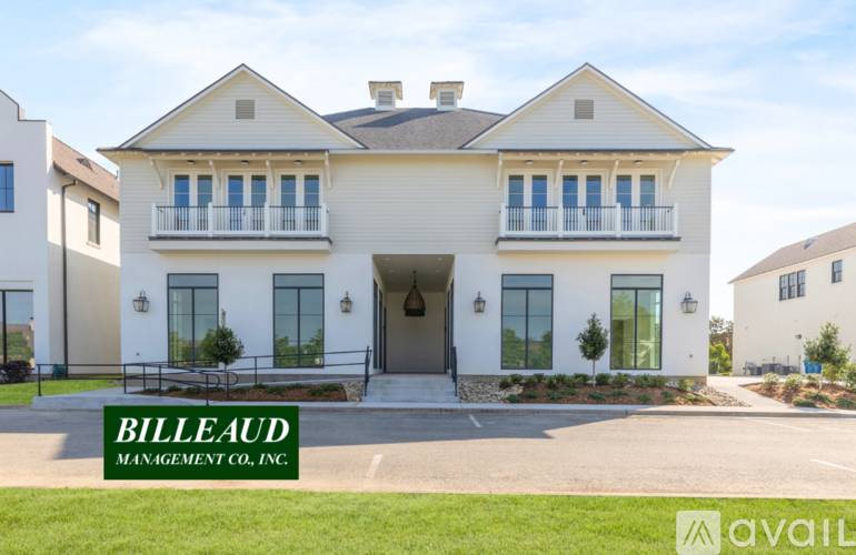 A large white house with a sign that says "BILLEAUD MANAGEMENT CO., INC." in front of it.