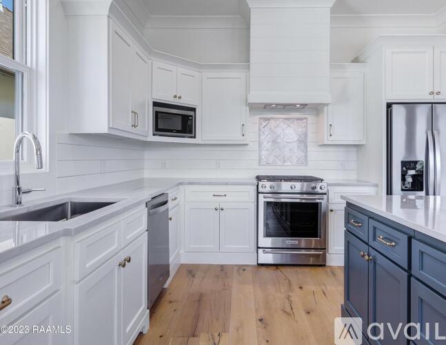 A kitchen with white cabinets and a wooden floor.