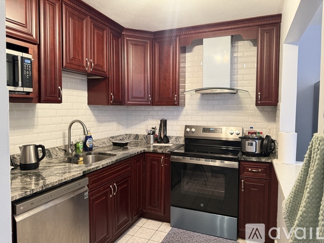 A kitchen with dark wood cabinets and stainless steel appliances.