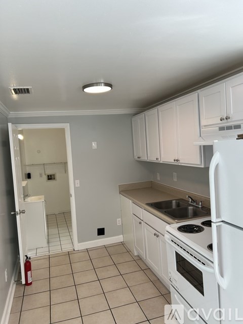 A kitchen with white appliances and cabinets.