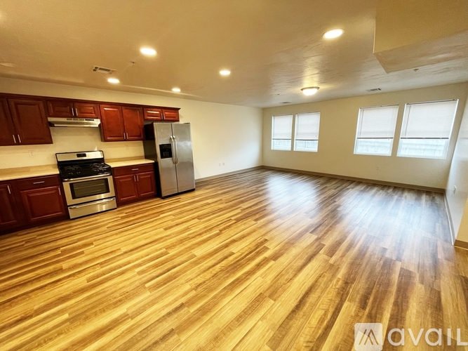 A kitchen with wooden floors and a refrigerator.