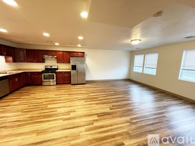 A kitchen with wooden floors and a refrigerator.