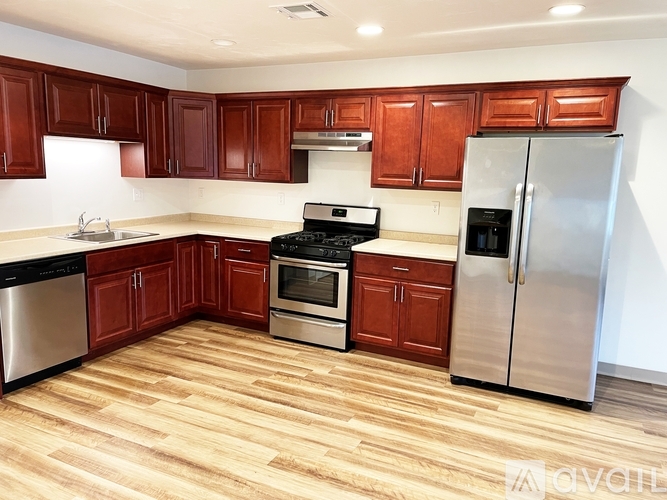 A kitchen with wooden cabinets and stainless steel appliances.