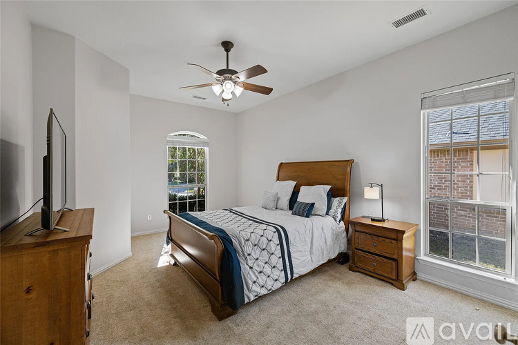 A bedroom with a bed, dresser, and television.