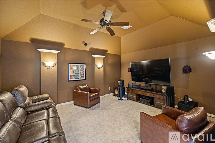A living room with a brown leather couch and a flat screen TV.