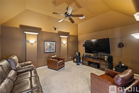 A living room with a brown leather couch and a flat screen TV.