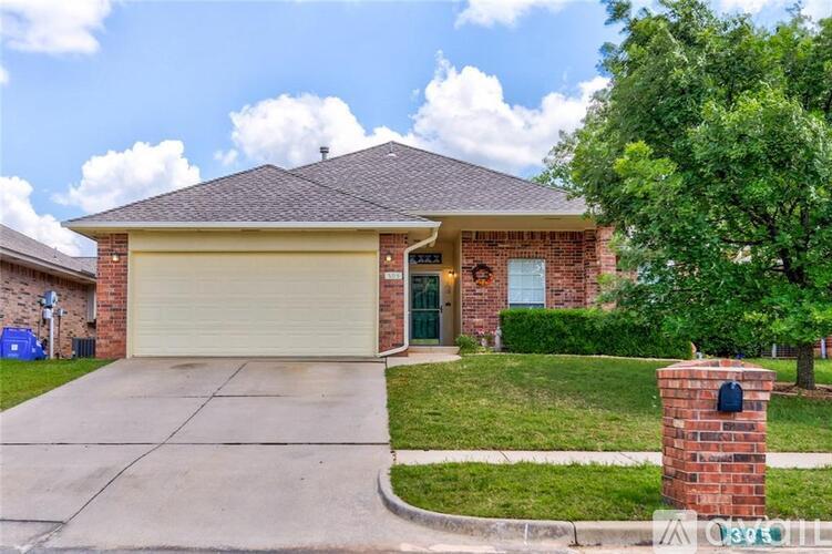 A house with a brick pillar in front of it.