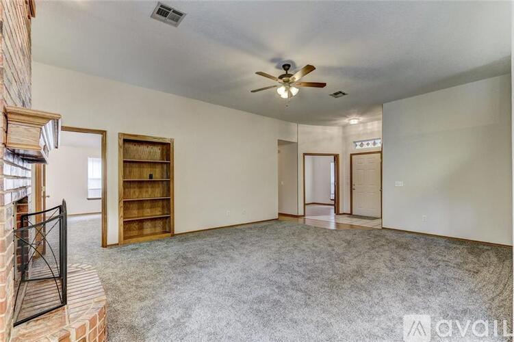 A spacious room with a ceiling fan and a bookshelf.