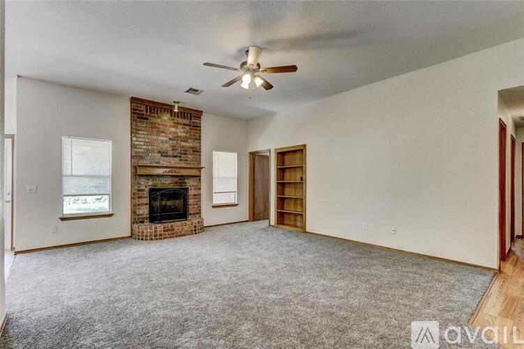 A living room with a fireplace and a ceiling fan.