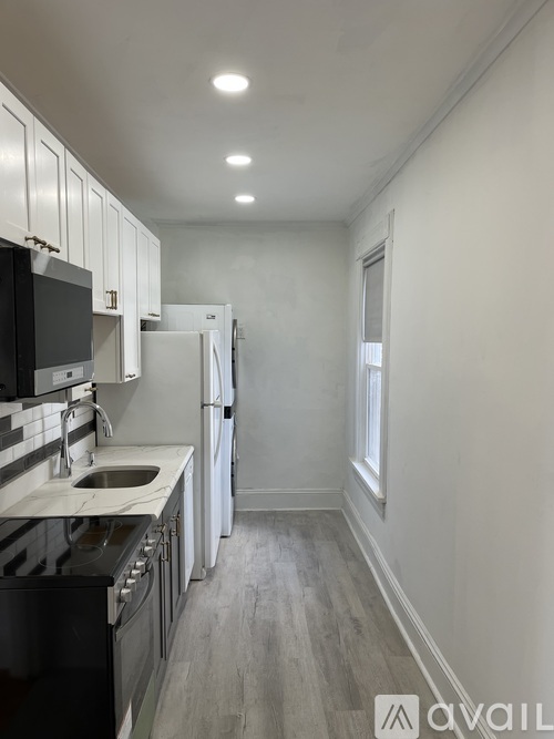 A kitchen with black appliances and white cabinets.