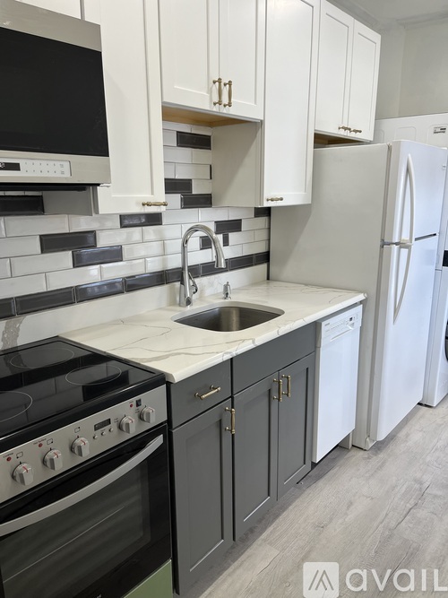 A kitchen with a black stove top oven and a white refrigerator.